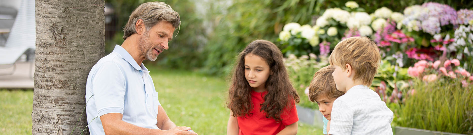 Großvater verbringt einen Tag im klimaangepassten Garten mit seinen Enkelkindern