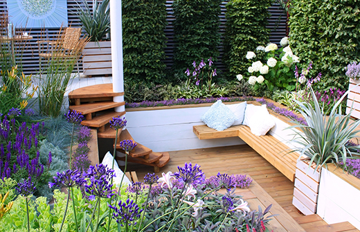 Garten gestaltet mit Holzelementen und Stauden